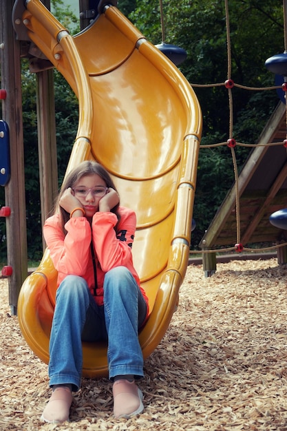 Foto l'adolescente è tristemente sola nella foto del parco giochi