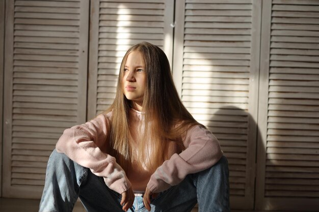 девочка-подросток в джинсах и розовом свитере с разными проблемами настроения подростка