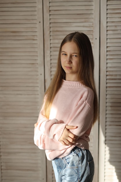 a teenage girl in jeans and a pink sweater with a different mood problems of a teenager