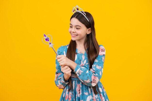 Teenage girl kid princess on yellow background Romantic wonderland story Little fairy girl with crown and magic wand putting spell