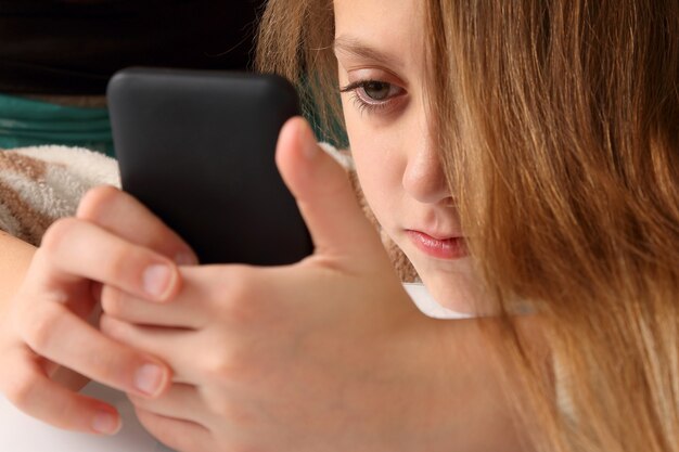 Foto ragazza adolescente guardando il telefono cellulare