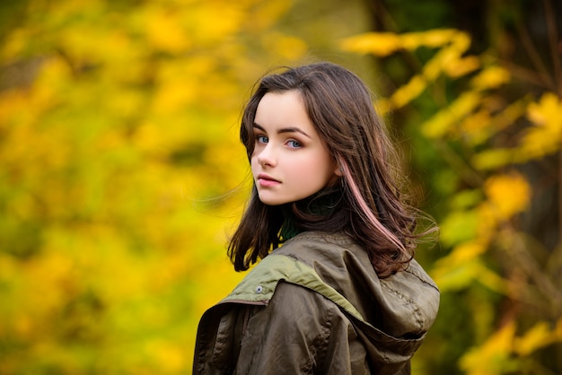 公園で10代の少女。秋の季節。晴れた日に美しい笑顔の女の子ティーンエイジャーの肖像画。