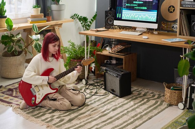 Photo teenage girl playing bass guitar at home