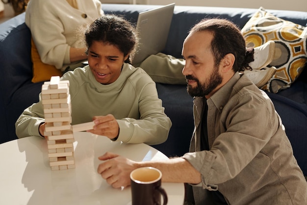 Teenage girl playing jenga with dad