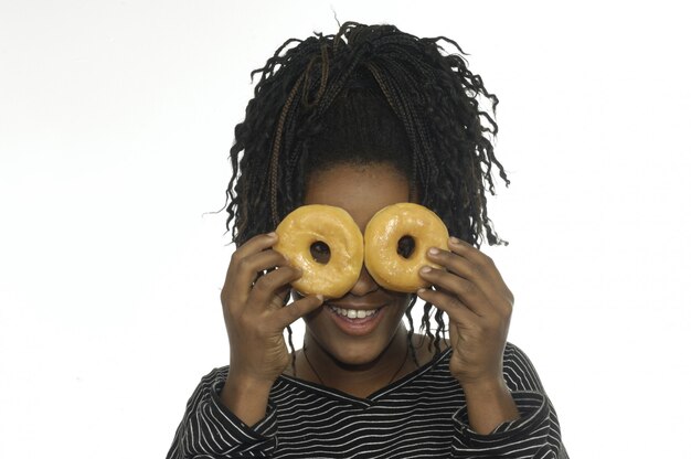 Teenage girl playing with donuts