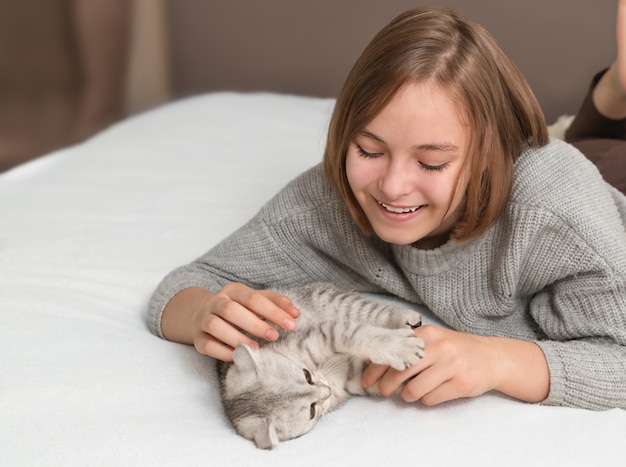 Teenage girl playing with a kitten