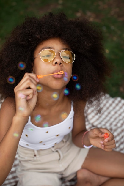 Teenage girl playing with soap bubbles