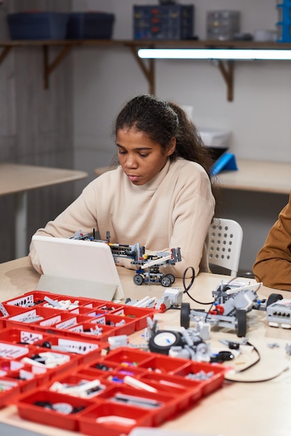 学校でロボットを投影する10代の少女