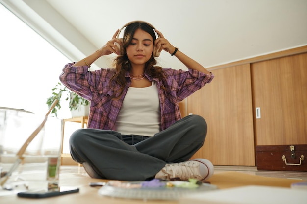 Photo teenage girl putting on headphones