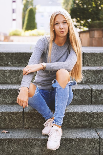 Photo teenage girl sitting on steps outside