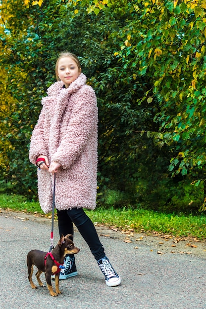 Teenage girl in sneakers on a walk with the dog