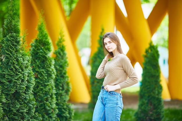 Teenage girl on the street on a cool summer day in a sweater and jeans