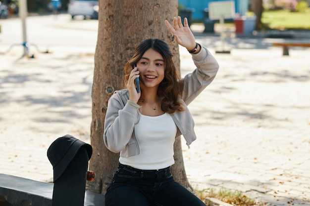 Teenage Girl Taking on Phone and Waving with Hand