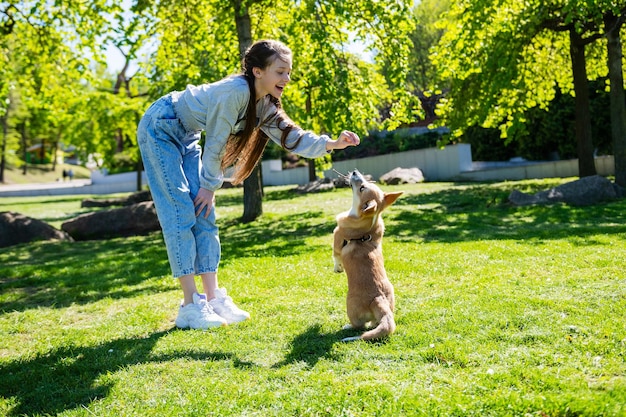 Adolescente che prende in giro il suo cagnolino mentre ci gioca