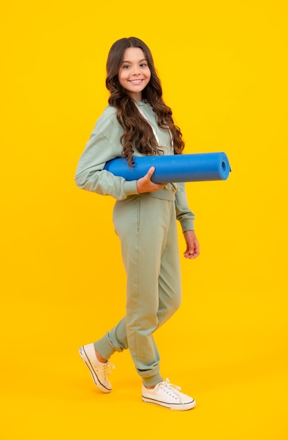 Teenage girl in track suit fashion sports wear isolated on yellow background Fitness sport child in sportswear sports clothing and shoes