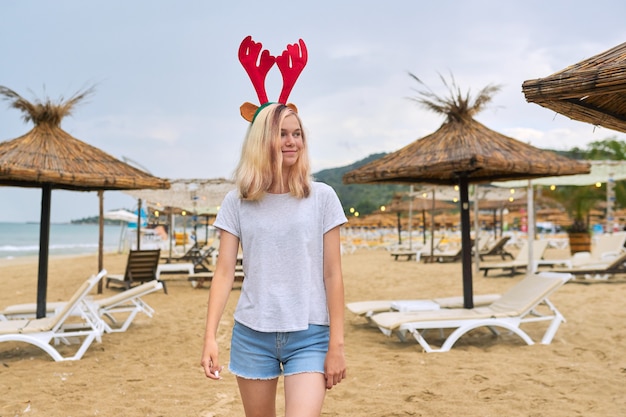 teenage girl walking on the beach in Christmas with deer ears