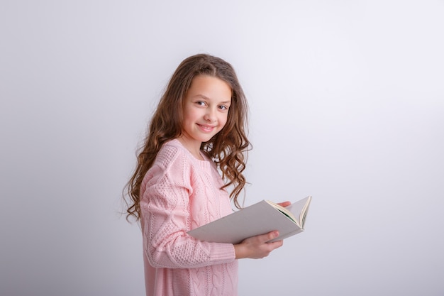 Teenage girl with a book in her hands on a white background. Shows emotions joy, surprise, sadness.