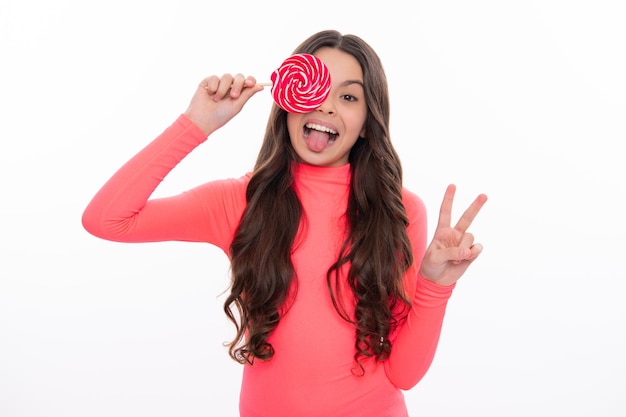 Teenage girl with candy lollipop happy child 12 13 14 years old eating big sugar lollipop sweets candy Excited face cheerful emotions of teenager girl