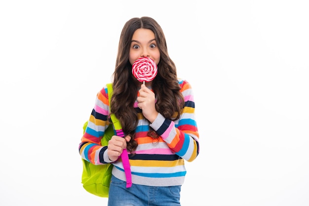 Teenage girl with candy lollipop happy child 12 13 14 years old eating big sugar lollipop sweets candy