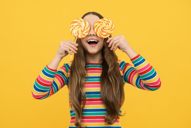 Teenage girl with candy lollipop happy child 12 13 14 years old eating big sugar lollipop sweets candy