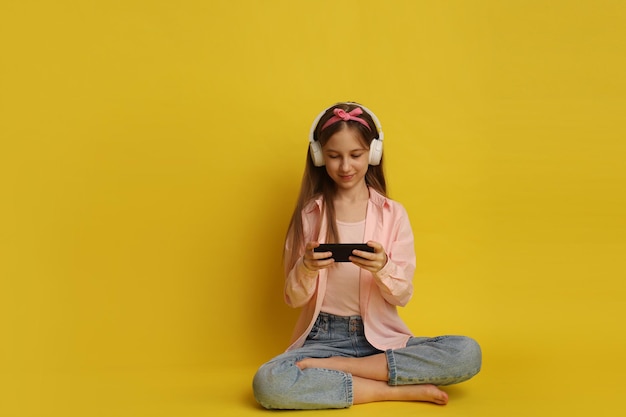 A teenage girl with gadgets headphones and a phone
