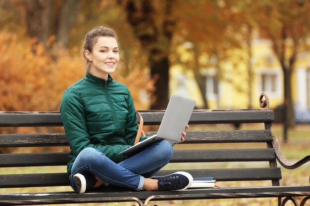 Photo teenage girl with laptop studying in park