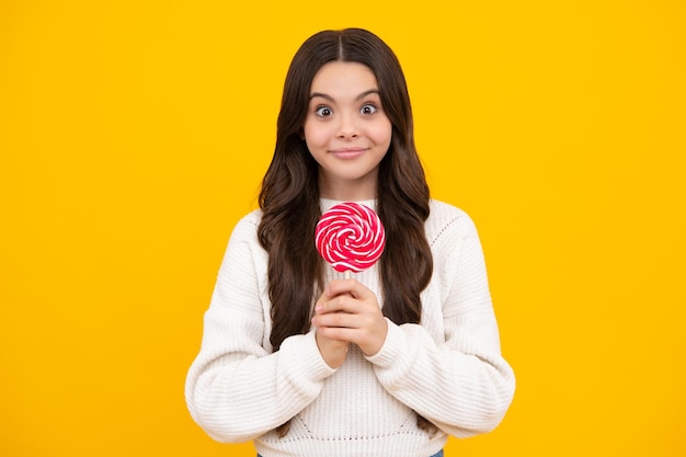 Teenage girl with lollipop child eating sugar lollipops kids sweets candy shop Excited teenager girl Happy face positive and smiling emotions of teenager girl