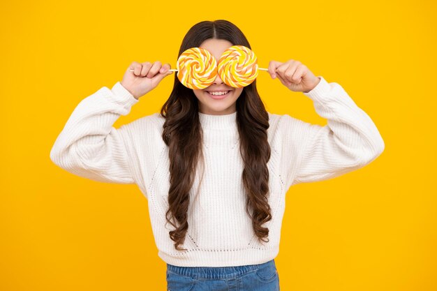 Teenage girl with lollipop child eating sugar lollipops kids sweets candy shop Excited teenager girl Happy face positive and smiling emotions of teenager girl