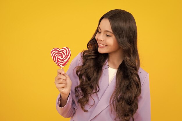 Teenage girl with lollipop child eating sugar lollipops kids sweets candy shop Excited teenager girl Happy teenager positive and smiling emotions of teen girl