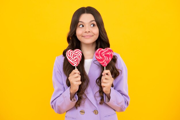 Teenage girl with lollipop child eating sugar lollipops kids sweets candy shop excited teenager girl happy teenager positive and smiling emotions of teen girl