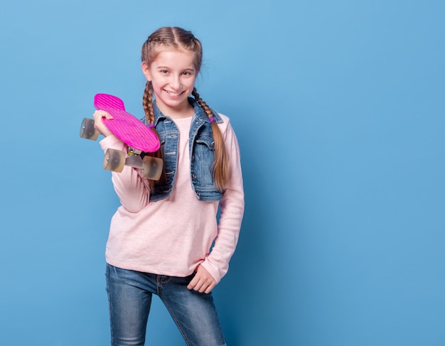 Teenage girl with pink skateboard