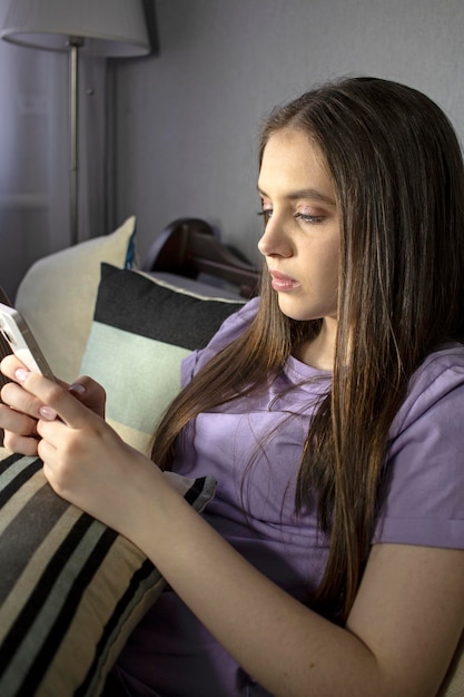 Teenage girl with a smartphone on the couch