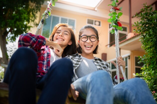 Photo teenage girls enjoy playing swing together,diverse ethnicities