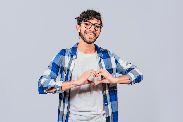 Teenage guy making heart shape with hands isolated Happy man making heart shape with hands isolated Person putting hands together in a heart shape