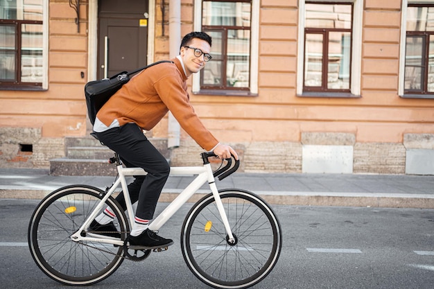 市内の自転車エコ輸送で月曜日に仕事のためにオフィスに行く 10 代の男性フリーランサー