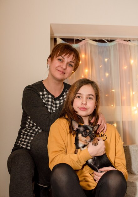 Teenage and mother and little chihuahua dog. Girl with mom at home