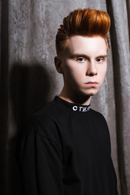 Teenage redhead boy haircuts hairdresser in the Barber shop