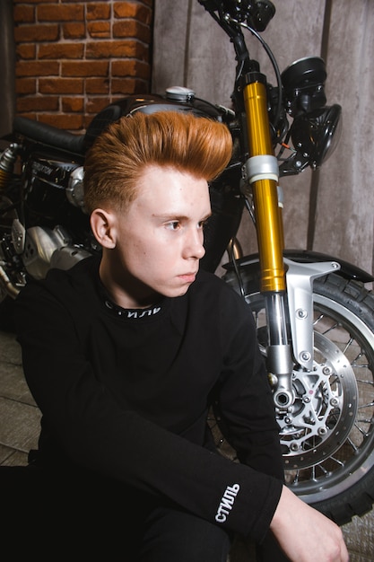 Teenage redhead boy on motorbike, haircuts hairdresser in the Barber shop.