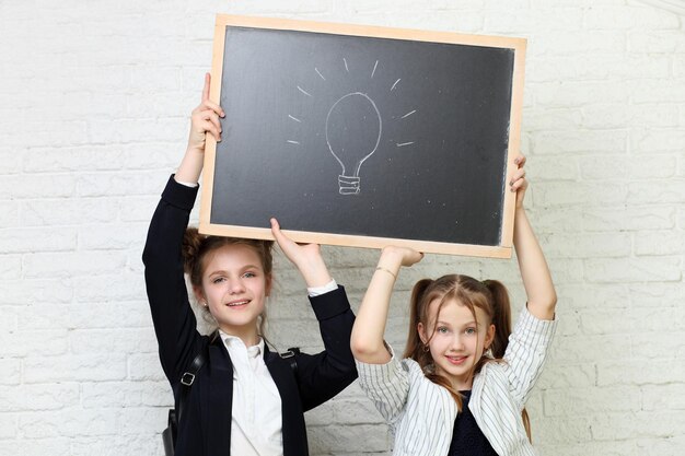 Teenage smiling girls holding blank presentation board Young women showing banner sign billboard