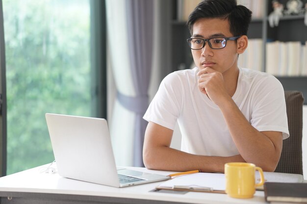 teenage student man teenager  working with computer studying learning online at home e-learning