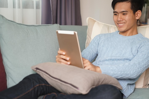 Teenage student man teenager working with tablet computer studying learning online at home