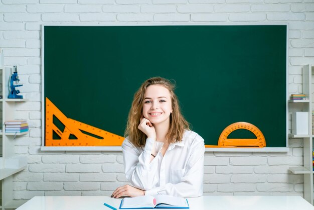 Teenage student in uniform on blackboard background