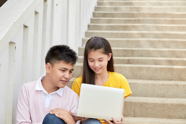 Teenage students work school job on laptop