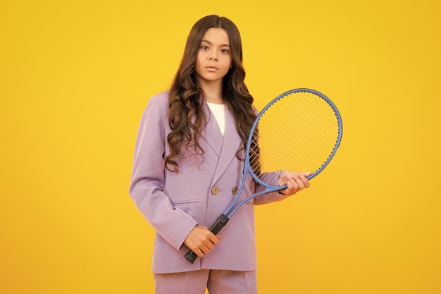 Teenage tennis player girl hold tennis racket over isolated yellow background Sport for kids Training for young kid Child learning to play tennis