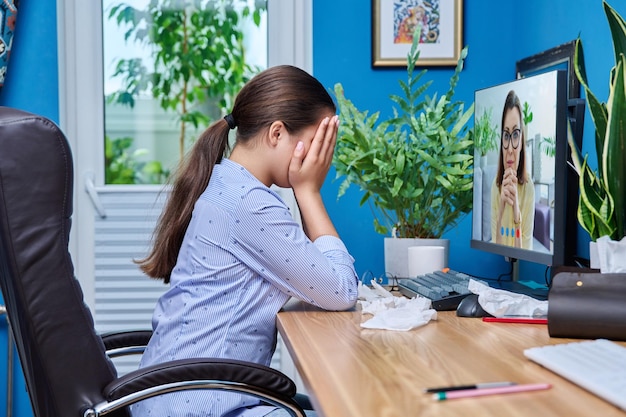 Photo teenage upset crying girl on online therapy with a psychologist