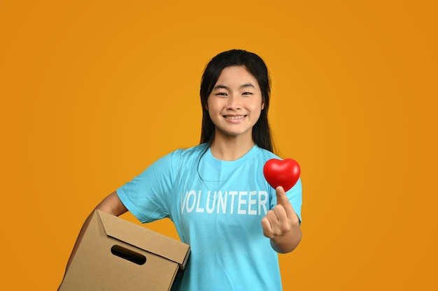 Photo teenager asian girl wearing volunteer tshirt isolated on yellow background charity support
