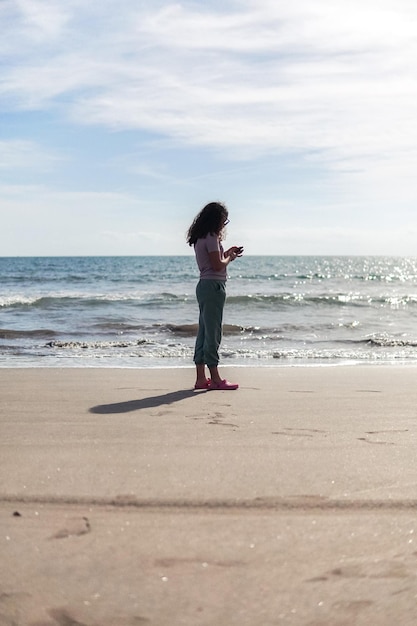 Photo teenager in beach using her cellphone