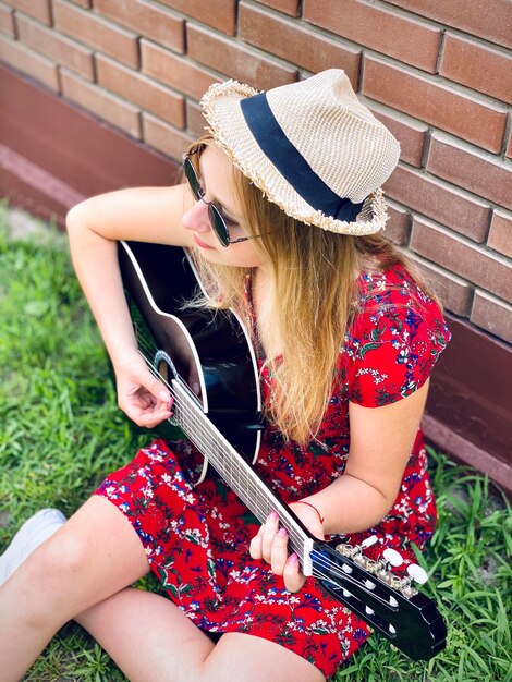 Photo teenager beautiful girl playing guitar outside