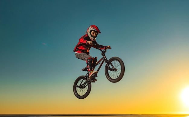 Photo a teenager bmx racing rider performs tricks in a skate park on a pump track