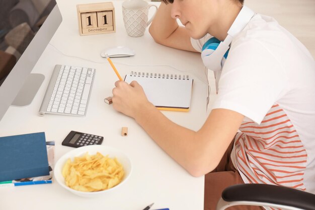 写真 屋内で宿題をしている 10 代の少年